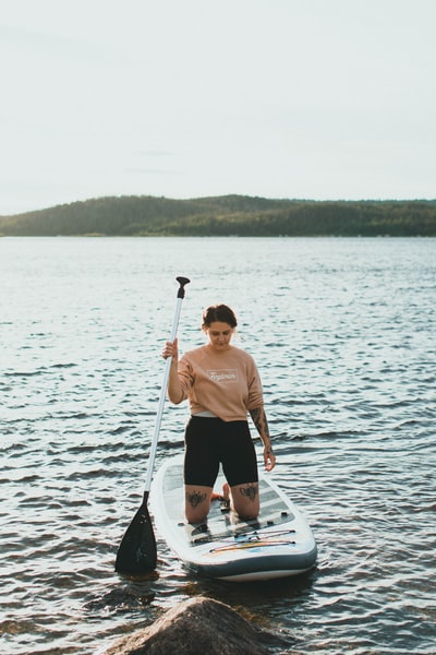 Dressed in a brown round collar T-shirt and black shorts man standing on the white during the day
